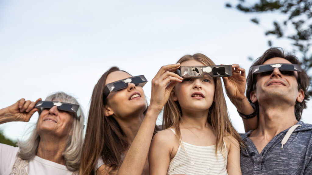 A family observes a solar eclipse