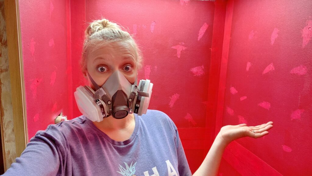 Rae with a mask after finishing painting RedGard in the shower during our RV bathroom renovation.  