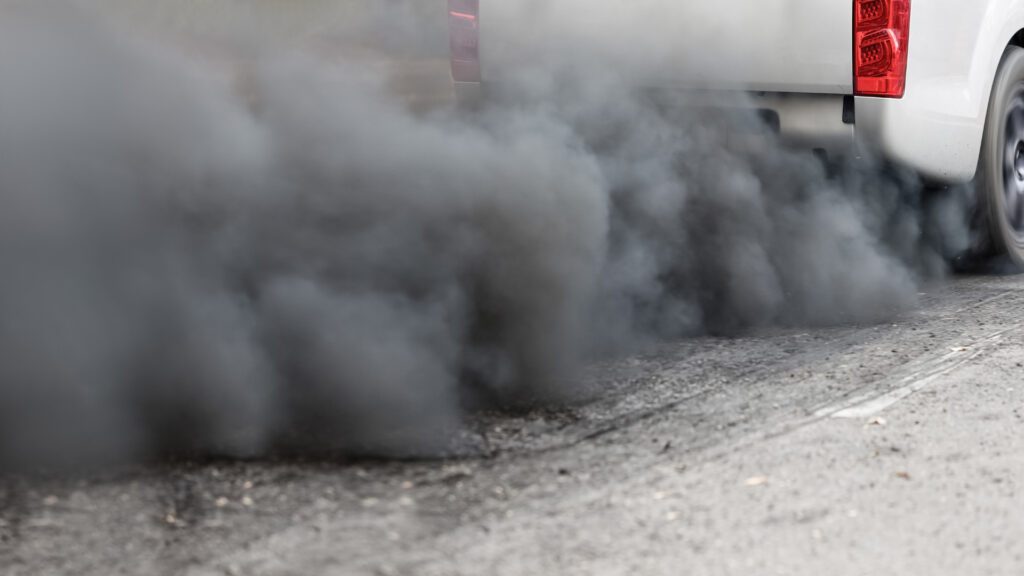 An extinguished truck on the road spreading pollution.